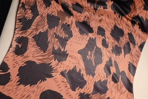 Close-up of leopard print chiffon fabric texture with warm brown and dark coffee tones