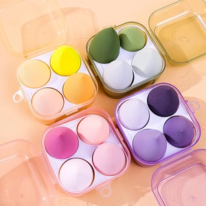 Set of four makeup sponge boxes in diverse colors within clear storage containers