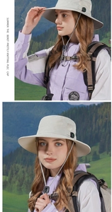 Detail of light grey sun hat with breathable mesh and decorative compass for hiking