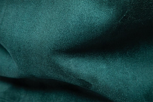 Macro texture of premium dark teal suede fabric with soft finish and elegant draping