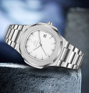 Detailed close-up of a silver watch with white dial, calendar window and steel strap