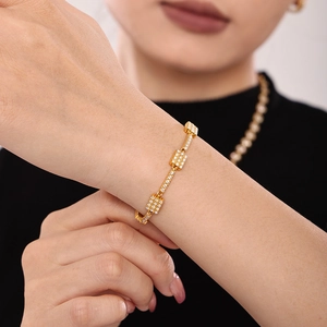 Gold plated stainless steel bracelet with zircon squares on woman wrist