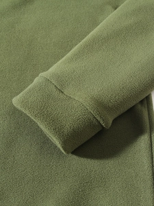 Detailed close-up of dark green coral fleece sleeve cuff showing soft texture