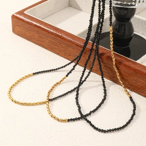 Detailed macro of black faceted beads and gold oval links on minimalist choker necklace