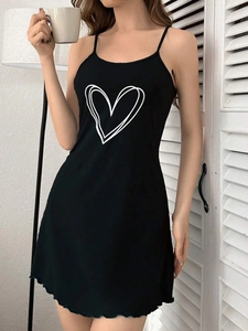 Detail of black nightdress featuring fine spaghetti straps and heart print with ruffle hem