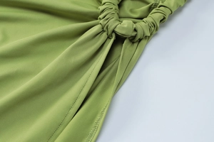 Macro view of green knitted fabric with side ruching and ring drawstring detail