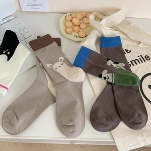 Detailed flat lay of three pairs of cotton socks with cartoon cat, alpaca, and dog patterns