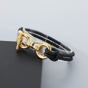 Close-up of black braided leather bracelet with golden 304 stainless steel horseshoe clasp
