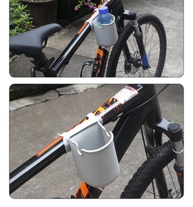 Close-up of grey silicone cup holder attached to a bicycle frame in outdoor scenery