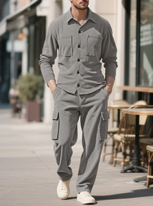 Close-up of men's gray corduroy utility jacket and matching pants in urban street setting