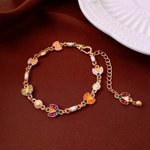 Detail of colorful ladybug enamel charms on a gold adjustable chain bracelet