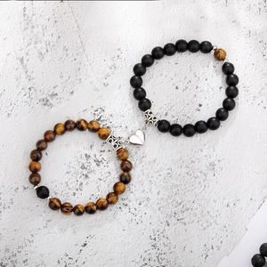 Close-up of magnetic heart clasp on natural tiger eye and matte black stone bracelets