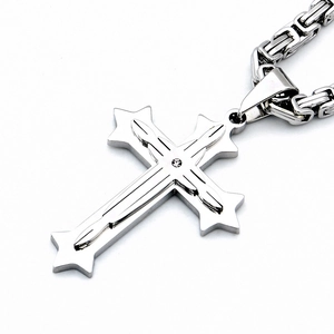 Détail du pendentif croix en acier inoxydable argenté avec zircon et chaîne à gros maillons