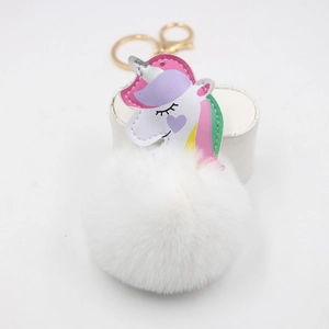 White faux fur pompom keychain with a pastel pink and purple unicorn charm and gold ring