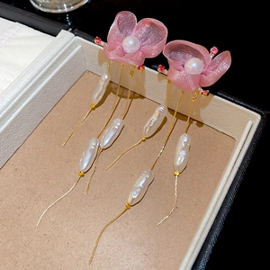 Detailed macro view of pink chiffon flower earrings with pearls and long chain tassels