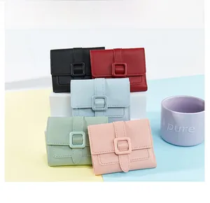 Dettaglio di piccoli portafogli in pelle dai colori pastello con fibbia quadrata chic
