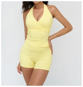 Detail of V-neck halter yoga top and high-waist shorts in bright yellow stretch fabric