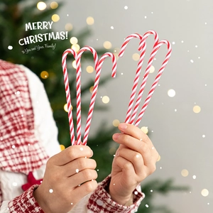 Classic red and white Christmas candy cane decoration held in a festive holiday setting