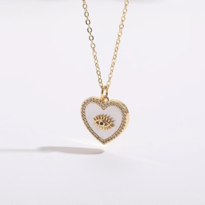 Macro shot of 14K gold plated heart necklace with evil eye shell and zircon accents