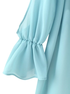 Detailed view of light blue chiffon blouse showing elegant flared cuffs and pleated texture
