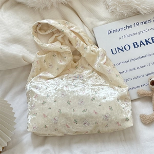 Detail of a creamy beige silk tote bag with cute bear and bow prints and brand label