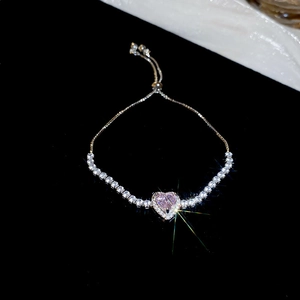 Macro detail of heart-shaped pink crystal bracelet with adjustable slider clasp closure