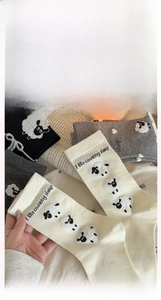Détail de chaussettes en coton avec motif mouton en noir, gris et beige