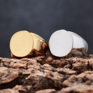 Close-up of gold and silver minimalist signet rings on natural tree bark background