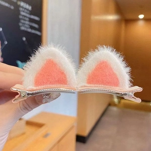 Close-up of plush cat ear hair clips for girls with soft pink and white faux fur detail