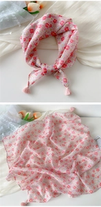 Detail of pink floral cotton linen scarf featuring delicate tassels and soft fabric texture