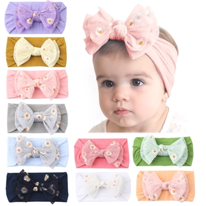 Detail of baby nylon headbands with large mesh bows and daisy embroidery in 10 colors