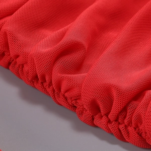 Gros plan sur le tissu en maille rouge avec fronces élastiques et texture drapée de la robe