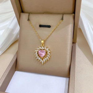 Macro detail of heart-shaped pink zircon pendant with marquise accents on gold chain