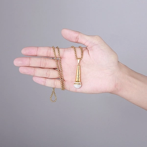 Detail of 18K gold hip-hop microphone pendant with sparkling crystals on a chain