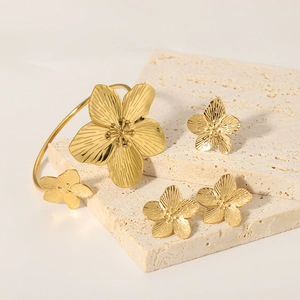 French vintage gold floral bangle and stud earring set on elegant stone base