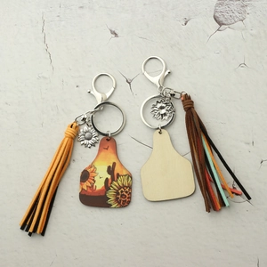 Detail of Western cowboy style sunflower wooden keychains with leather tassels and charms