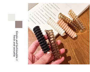 Détail des élastiques spirale pour cheveux en noir, marron et beige clair