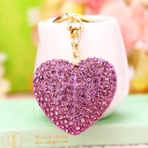 Macro shot of purple rhinestone heart keychain with gold metal chain and clasp detail