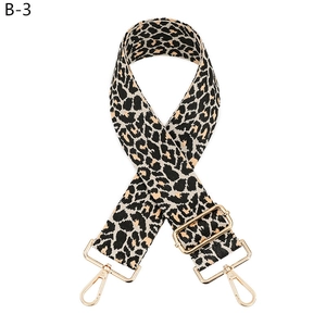 Macro detail of leopard print canvas strap with adjustable golden metal buckle