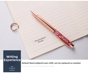 Detail of rose gold ballpoint pen with sparkling pink crystals on a notebook