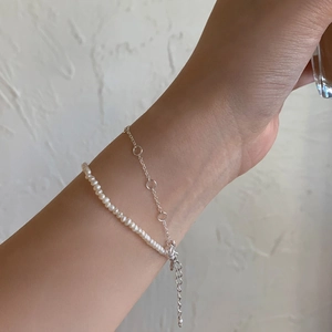 Close-up of a double-layer S925 silver chain and white rice pearl bracelet on a wrist
