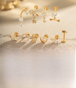 Detailed view of titanium alloy ear studs with zircon moon and fishbone designs