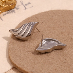 Detail of silver wavy water drop earrings featuring textured stripes and polished finish