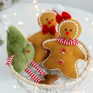 Christmas gingerbread man and plush tree ornaments in a woven basket with warm lights