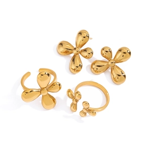 Golden clover jewelry set featuring adjustable rings and stud earrings in polished steel