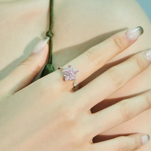 S925 silver spinning flower ring with pink stones and zircons on woman's hand