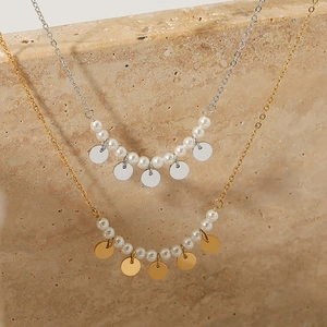 Minimalist stainless steel pearl necklace in gold and silver finish on textured stone