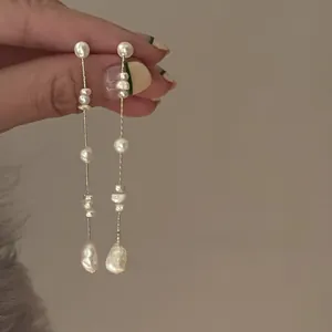 Detailed close-up of French vintage baroque pearl tassel earrings with gold-tone wire