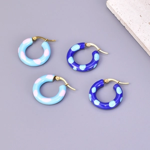 Detail of 18k gold plated hoop earrings with blue and pink enamel polka dot patterns