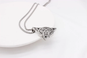 Detail of vintage Viking triangle pendant with occult symbols and motivational quotes
